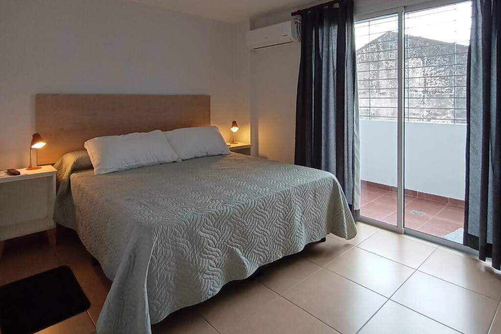 a bedroom with a bed and a large window at Las Piedras Apart in San Miguel de Tucumán