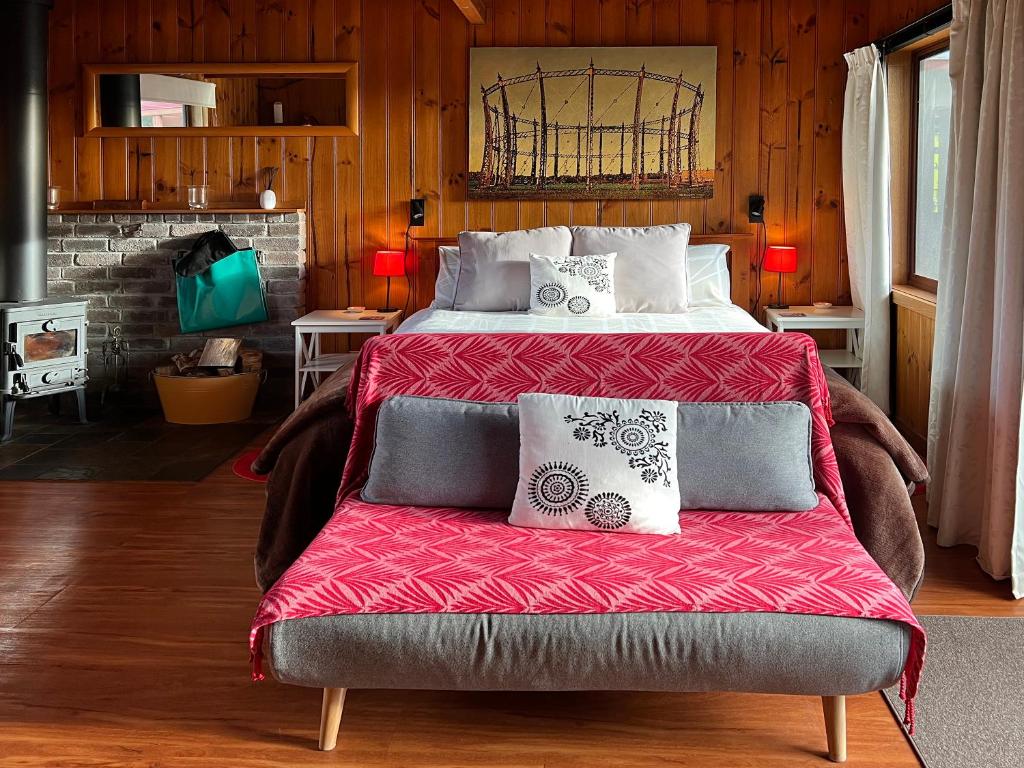 a bedroom with a large bed with a red blanket at Eagles Rise - The Cosy Cabin - 1hr Cradle Mountain in Gawler
