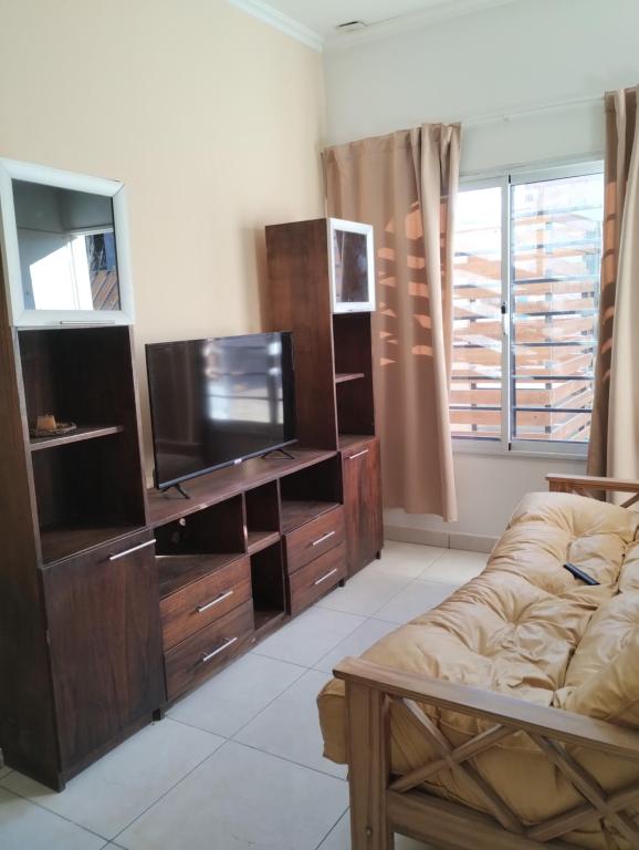 a living room with a couch and a flat screen tv at Depto Civora 2 in Villa Regina