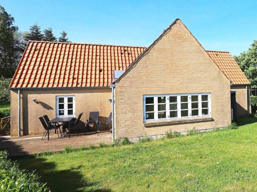 a brick house with a table and chairs in a yard at 6 person holiday home in Nykøbing M-By Traum in Sønder Dråby