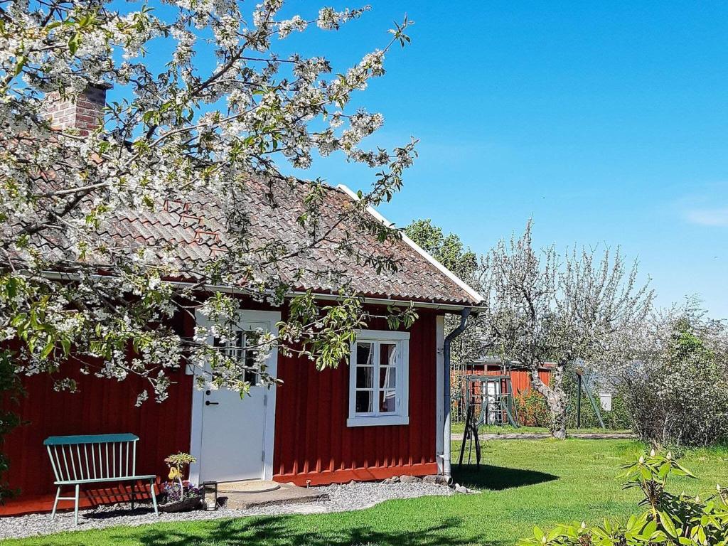 a red shed with a bench in a yard at 4 person holiday home in MARIESTAD-By Traum in Mariestad