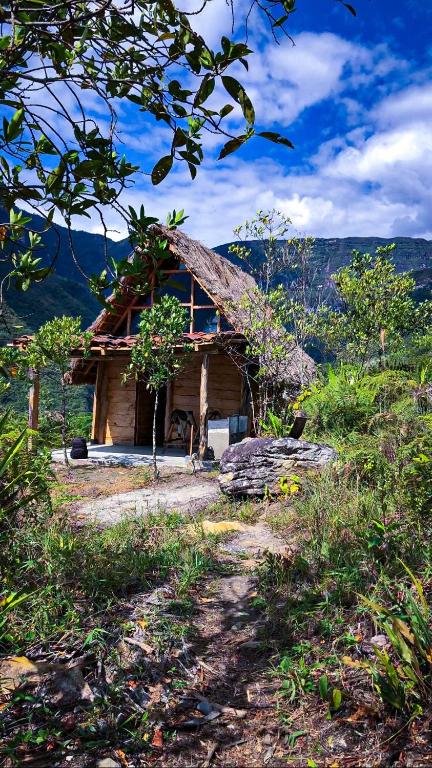 a log cabin in the middle of a field at Gocta Dulce Hogar in Cocachimba