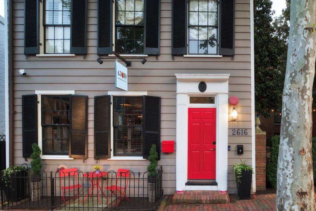 una casa con una puerta roja y ventanas negras en The Poppy Georgetown Guesthouse and Gardens, en Washington