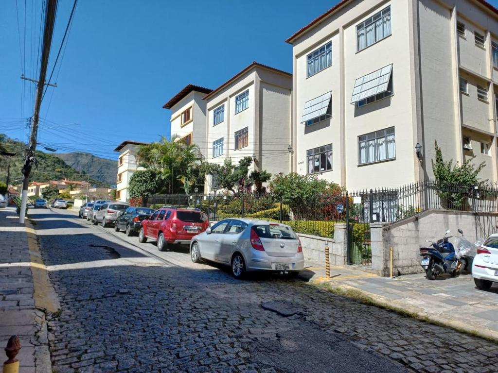 a street with cars parked in front of a building at Fonte da Serra in Teresópolis