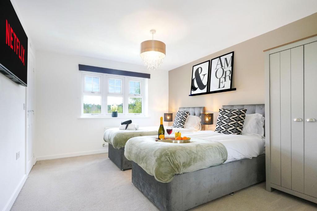 a bedroom with two beds and a window at Detached House with Free Parking, Super-Fast Wifi and Smart TV with Netflix by Yoko Property in Northampton