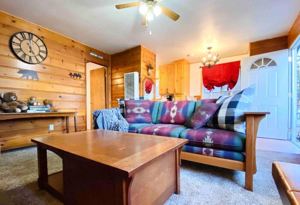 sala de estar con sofá y reloj en Cozy Spa Retreat Near Resorts and Snow Play, en Big Bear City