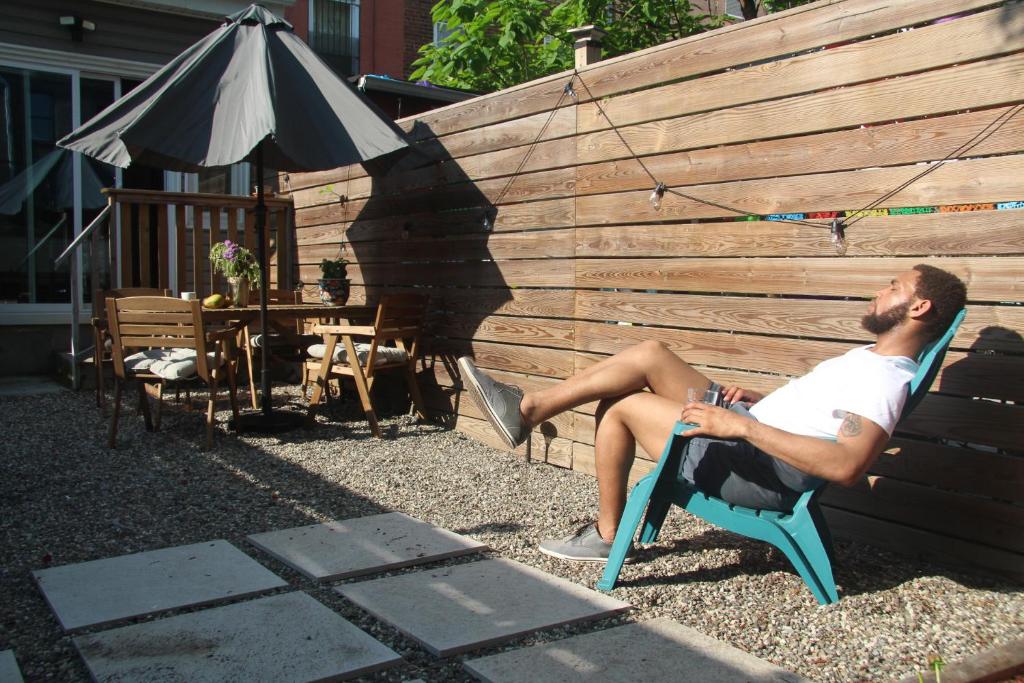 a man sitting in a chair next to a fence at Perfectly Located Modern 2BR w Priv Backyard in Brooklyn