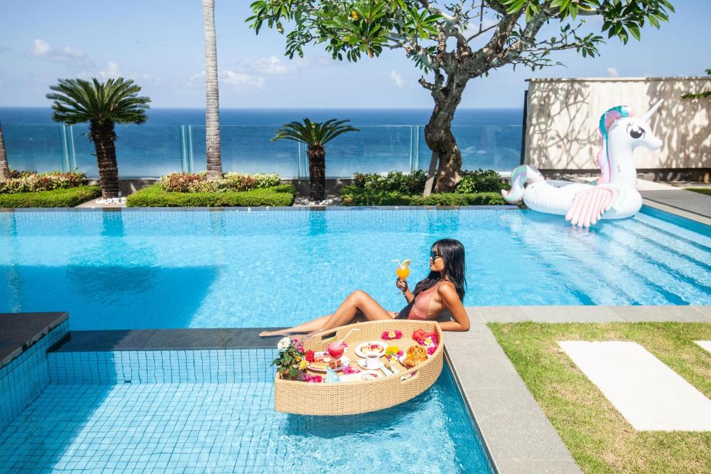 a woman sitting in a bath tub in a swimming pool at Cliff Front pandawa Beach Karang Kembar 5 in Ungasan