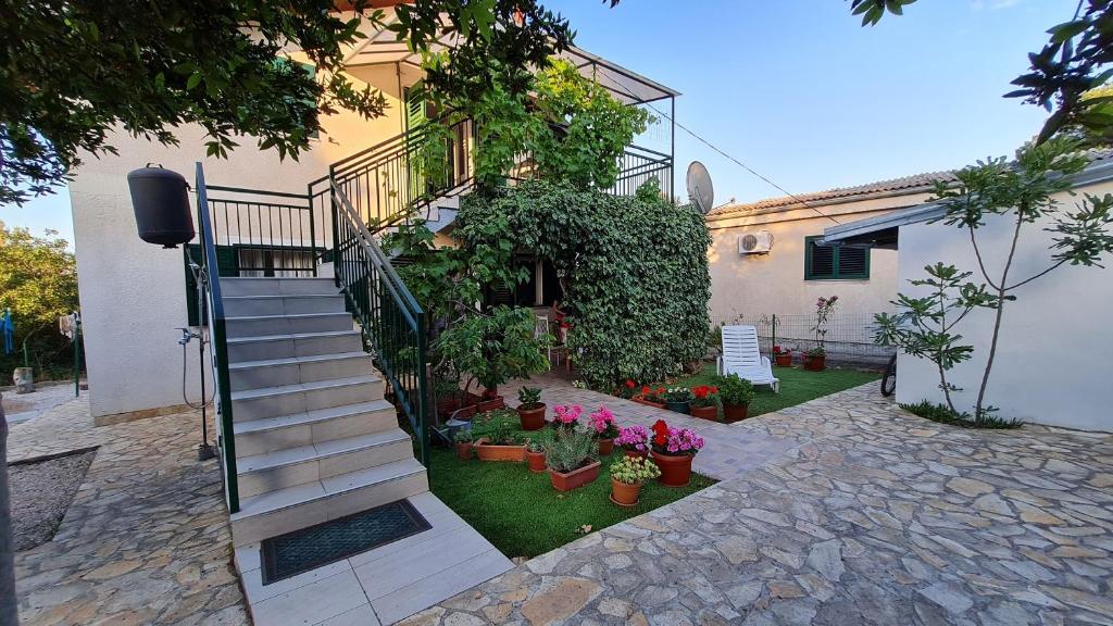 a staircase leading to a house with potted plants at House Maja in Jadrija