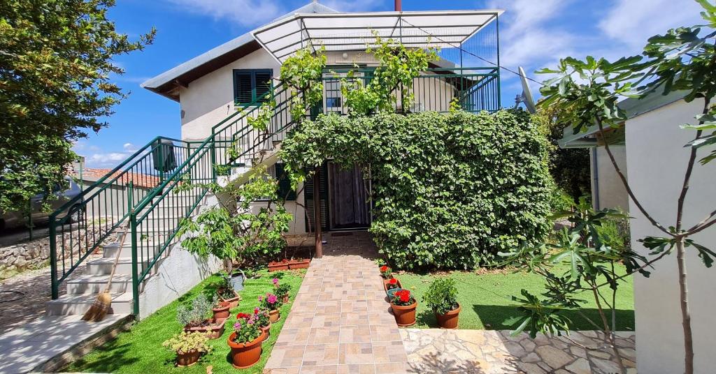 een huis met een tuin met potplanten bij House Maja in Jadrija