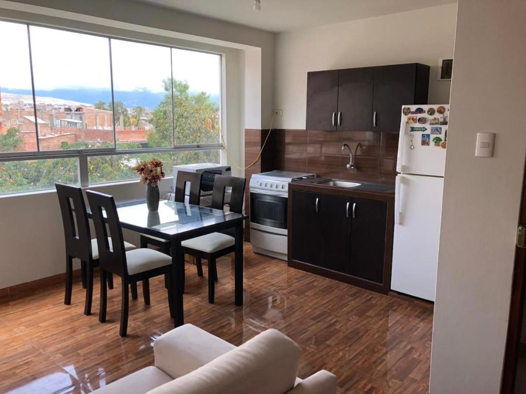 a kitchen with a table and chairs and a kitchen with a window at Departamento en el centro histórico in Ayacucho