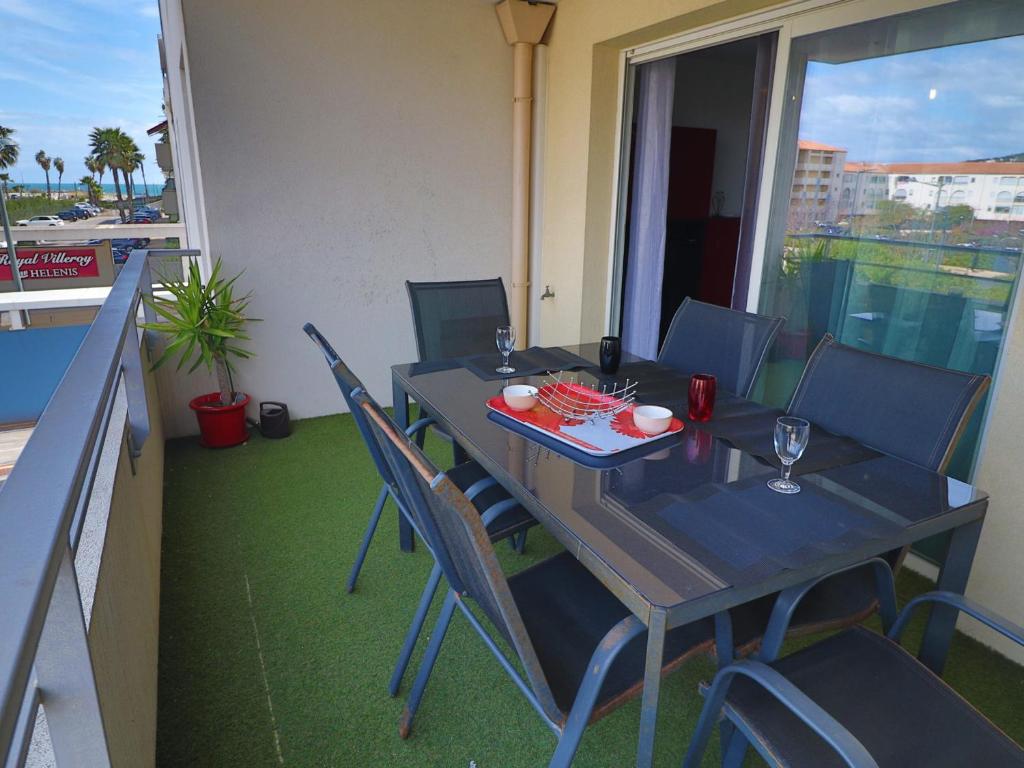 d'une table à manger et de chaises sur un balcon avec vue. dans l'établissement Charmant 2 pièces avec clim, parking et piscine, à 300m de la plage - Sète - FR-1-472-189, à Sète