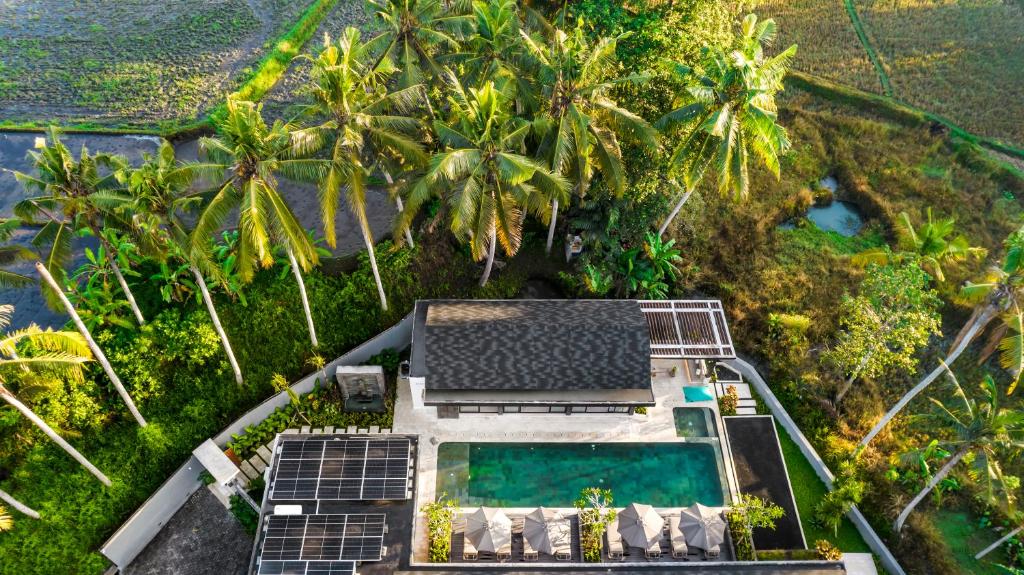an aerial view of a resort with a swimming pool and palm trees at Villa Jehanne by BaliSuperHost in Ubud