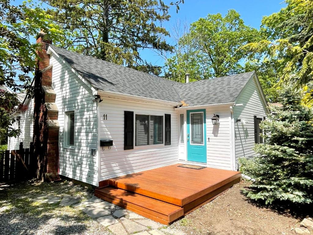 Cette petite maison blanche dispose d'une terrasse en bois. dans l'établissement Addison House License #041-2021, à Niagara on the Lake