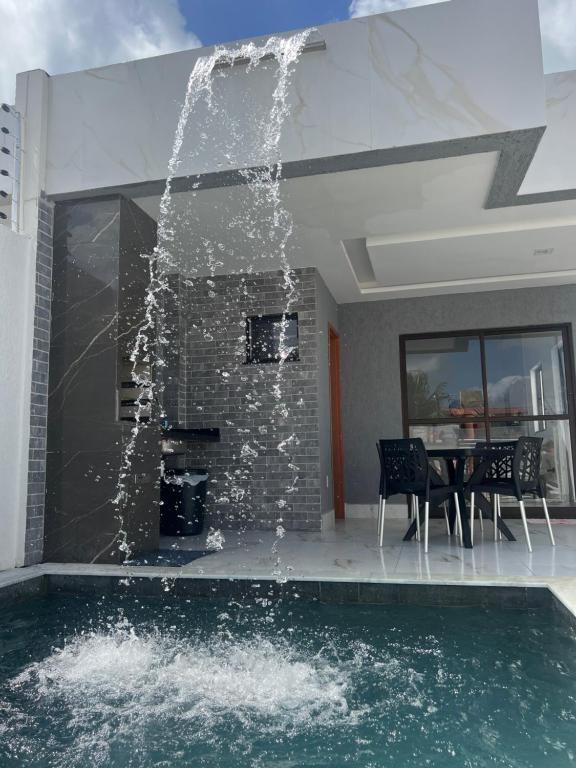 a swimming pool with a fountain in a house at Carapibus casa de praia 02 in Conde