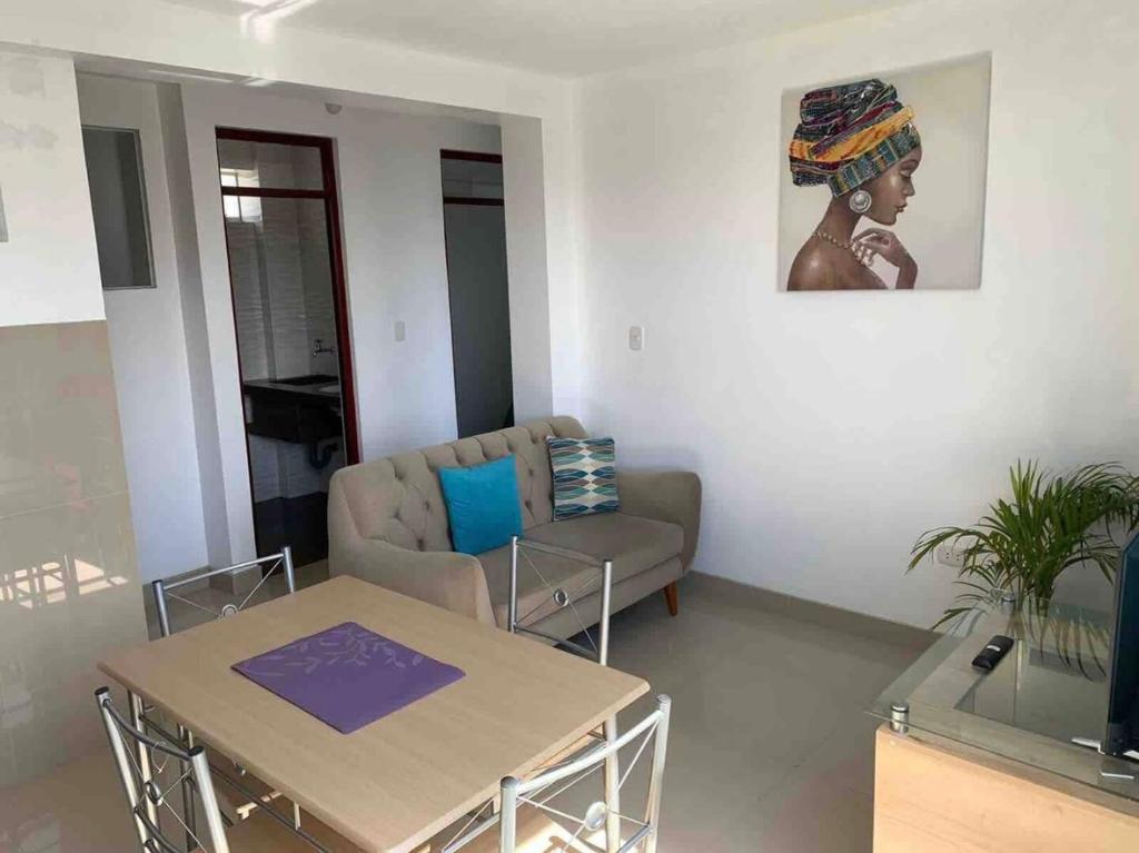 ein Wohnzimmer mit einem Sofa und einem Tisch in der Unterkunft Departamentos en centro histórico 1 in Ayacucho