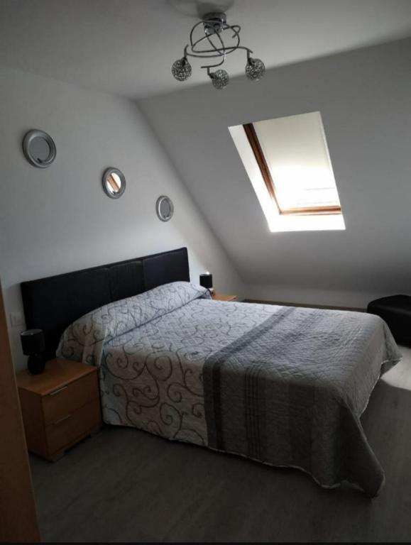 a bedroom with a large bed and a skylight at El pisin de Claudia in Colombres