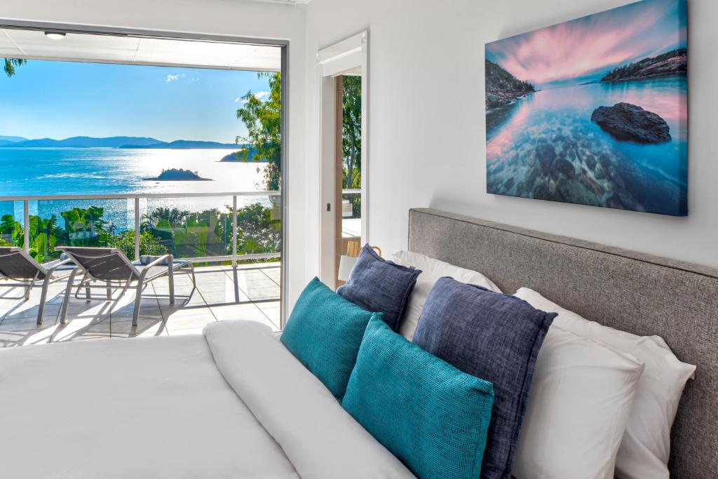 Blue Water Views 16 - 3 Bedroom Penthouse with Ocean Views في جزيرة هاميلتون: غرفة معيشة مع أريكة وإطلالة على المحيط