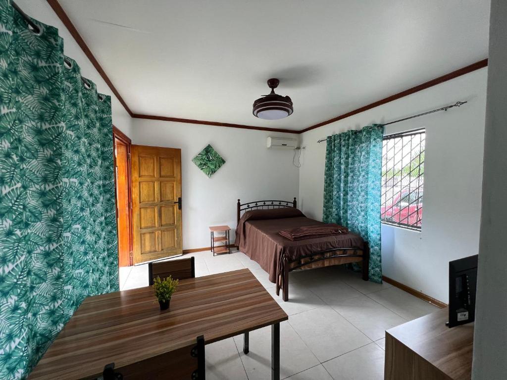 a bedroom with a bed and a table in a room at Pasifika Guesthouse in Nadi