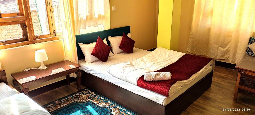 a small bedroom with a bed with red pillows at The Bliss Homestay in Gangtok