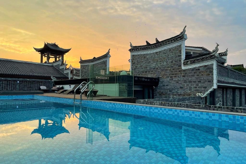 uma piscina em frente a um edifício em Phoenix Hall House Hotel em Fenghuang