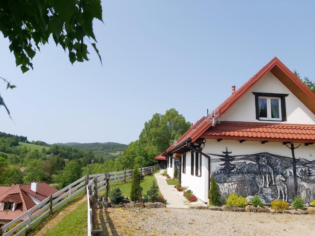 a house with a mural on the side of it at Domki nad Cichym Dworkiem in Polańczyk