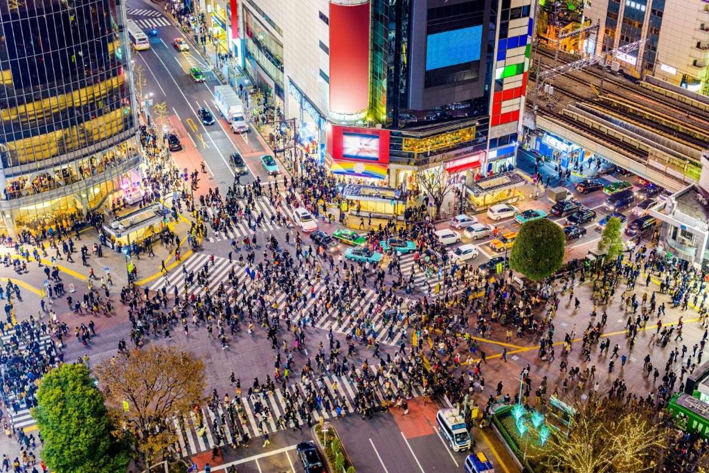 a crowd of people crossing a busy city street at 涩谷中心 ! 涩谷十字路口 109 Shibuya scramble crossing 高速无限制网络#703 in Tokyo