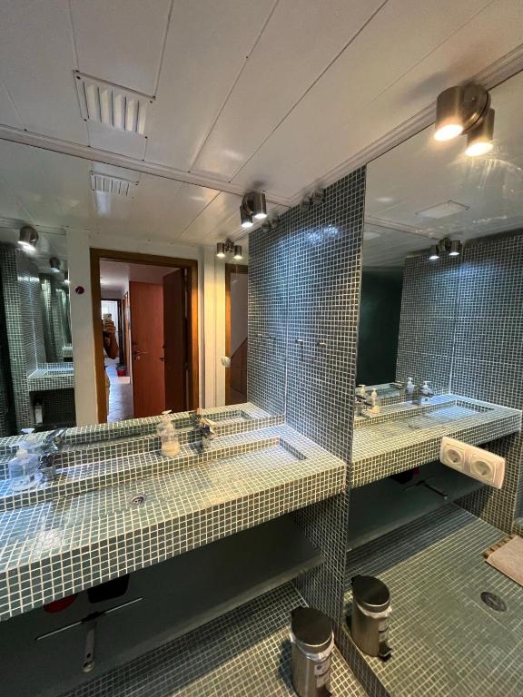 a bathroom with three sinks and a large mirror at Amazigh Guincho Hostel & Suítes in Cascais