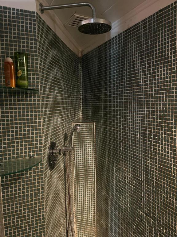 a bathroom with a shower with tiled walls at Amazigh Guincho Hostel & Suítes in Cascais