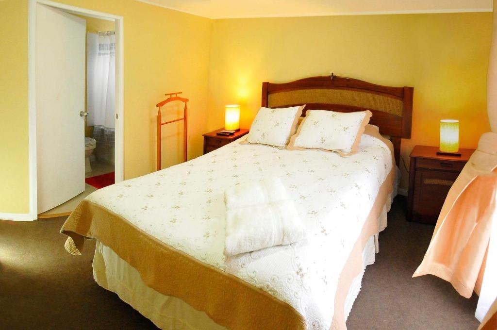 een slaapkamer met een groot bed met 2 nachtkastjes bij Alojamientos San Sebastián Talca in Talca