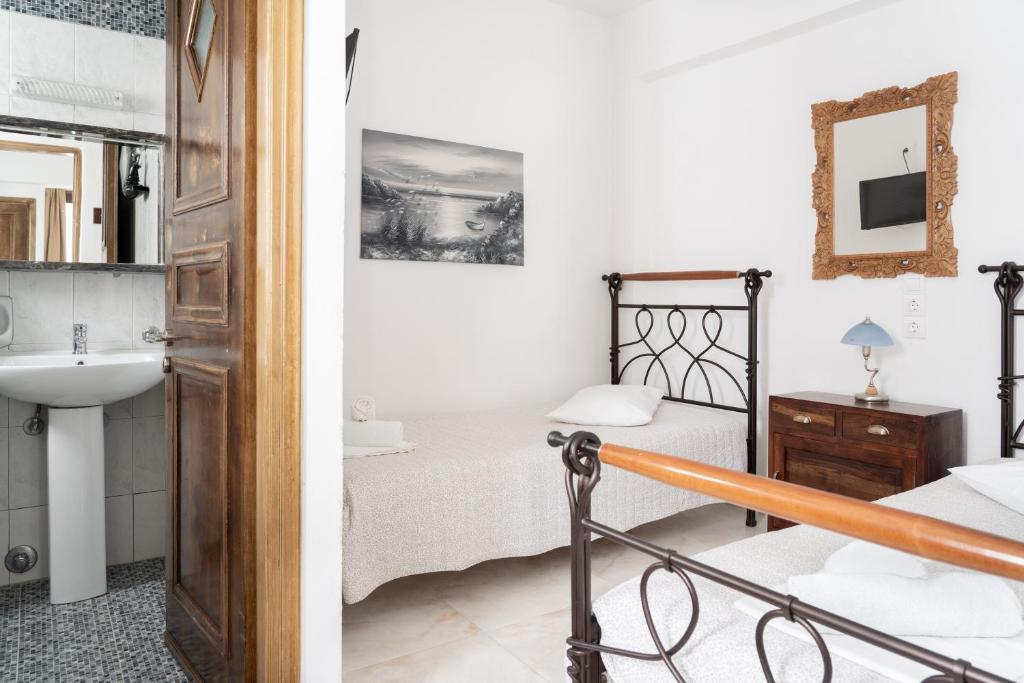 a bathroom and a bedroom with a bed and a sink at Alexandros by the Beach - Serifos in Livadakia