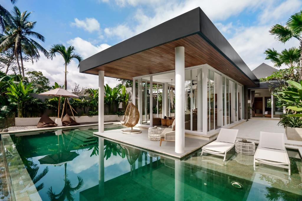 a villa with a swimming pool and a house at Villa Paso by BaliSuperHost in Ubud