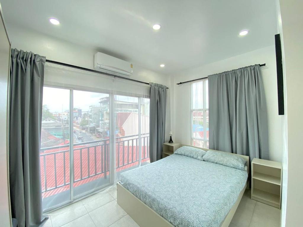 a bedroom with a bed and a large window at Shaka Guest House in Kata Beach