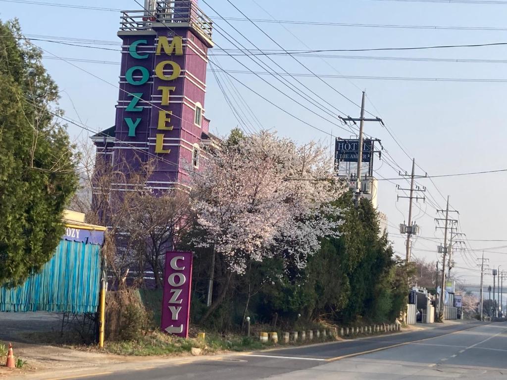 un edificio con un letrero al lado de una calle en Cozy Motel en Yangpyeong