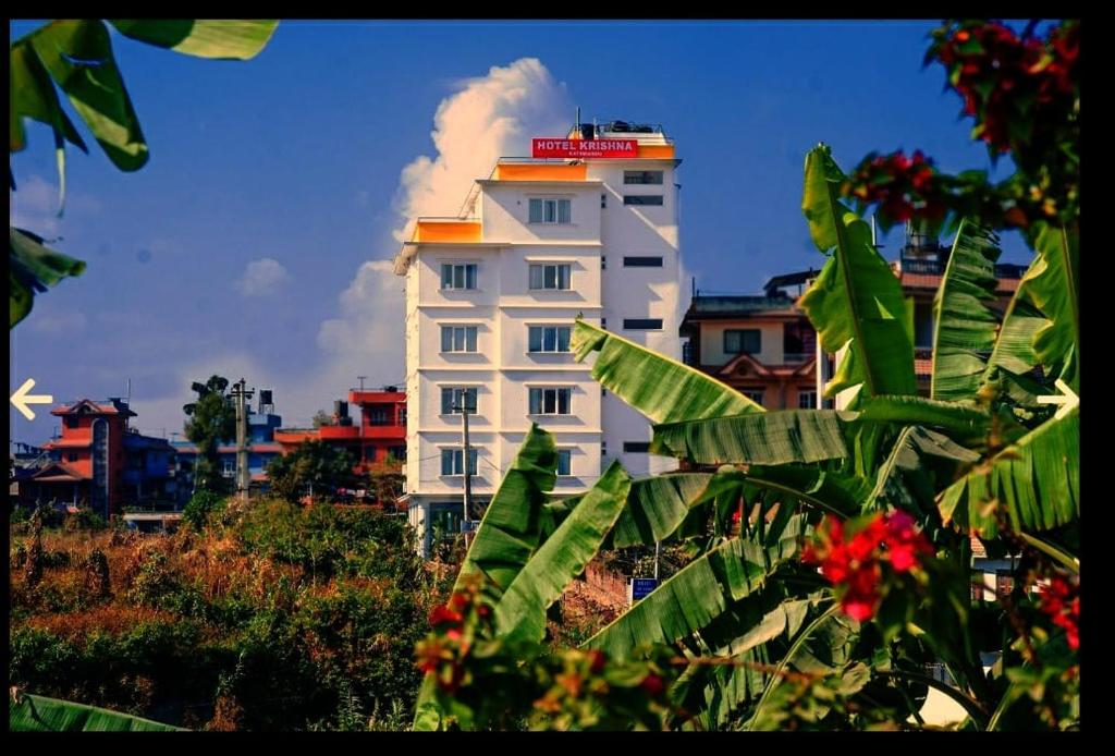 Hotel Krishna Kathmandu في كاتماندو: مبنى أبيض عليه علامة حمراء
