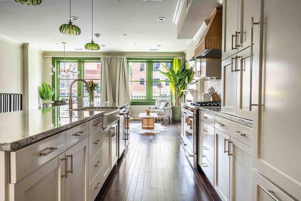 uma grande cozinha com armários brancos e uma grande ilha em Urban Oasis w/Sunroom-Downtown Columbia em Columbia