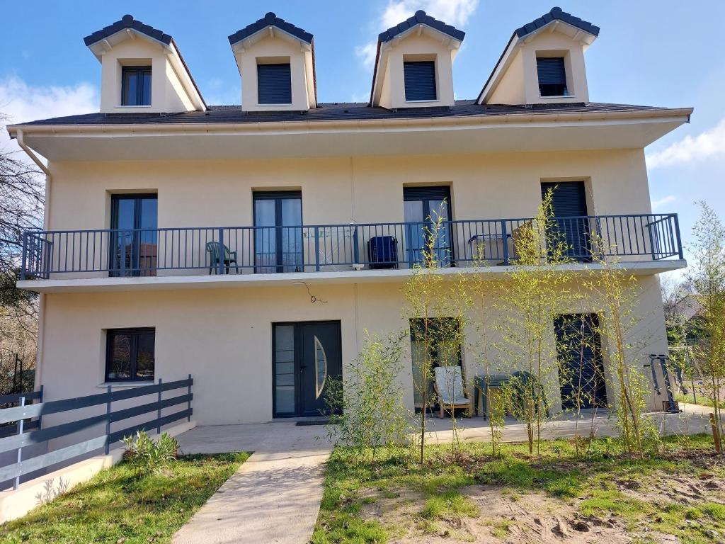 Una casa antigua con un balcón encima. en Résidence de la gare, chambre meublée en Longjumeau