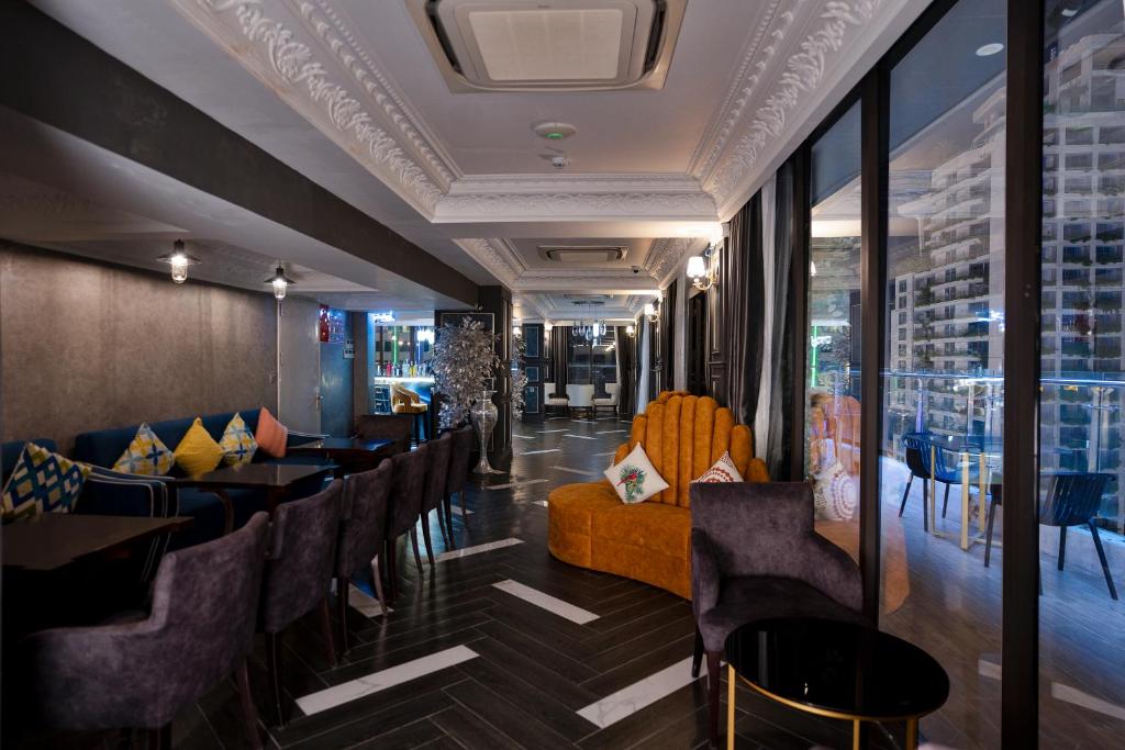 A dark, lounge-style restaurant with seating beside tall windows.