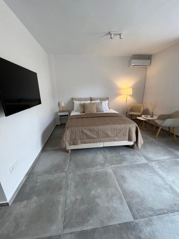 a bedroom with a bed and a flat screen tv at Modern & Cozy Studio in Koroni