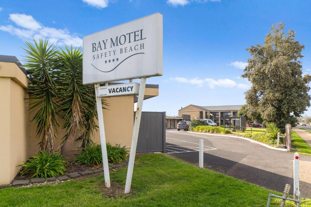 a sign for aay motel with a street holder at Bay Motel Safety Beach in Safety Beach