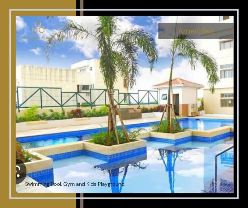 una piscina con 2 palmeras frente a un edificio en Spacious 3BR Condo Unit with Wi-Fi and pool access in San Juan near Greenhills, en Manila