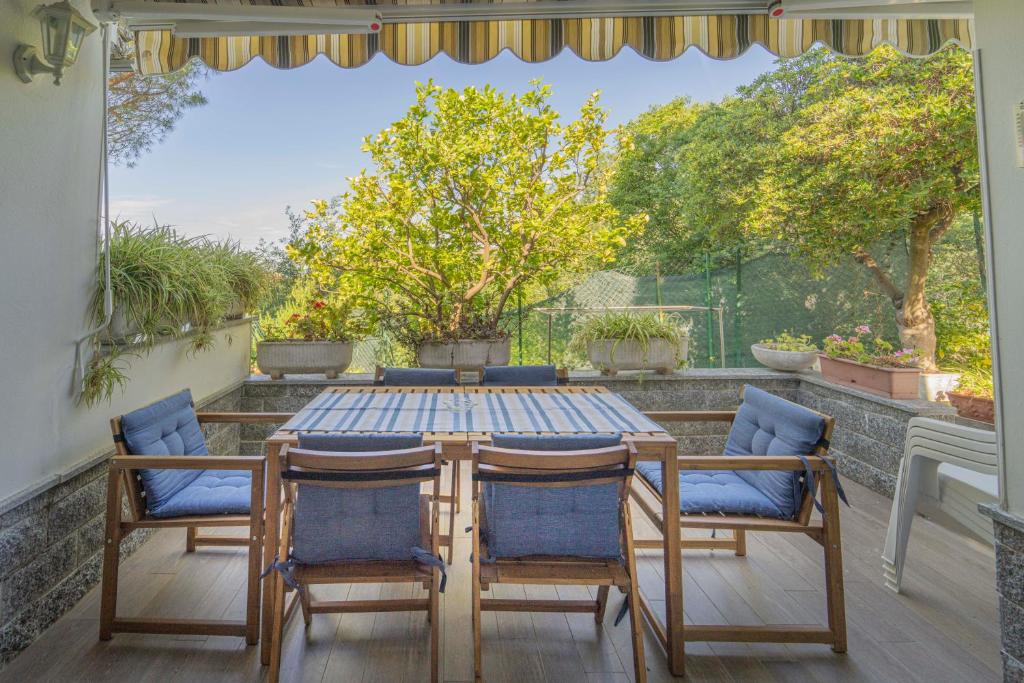 un tavolo e 4 sedie su un patio con vista di 070 - Villa OLANDA con veranda VISTA MARE a 5 minuti SPIAGGIA con PISCINA CONDOMINIALE a Sestri Levante