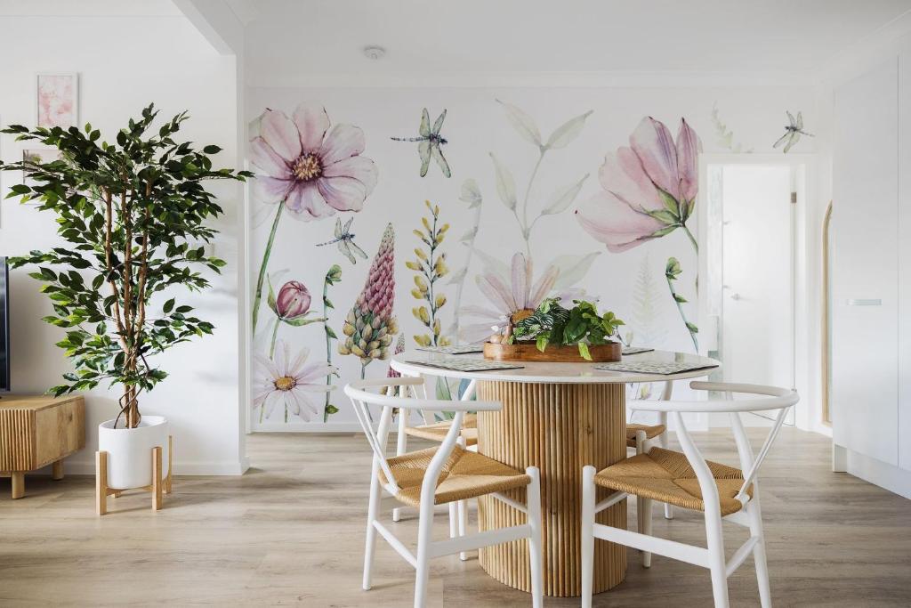尼尔森湾Little Beach Boutique Apartment的墙上装饰有花卉壁画的用餐室