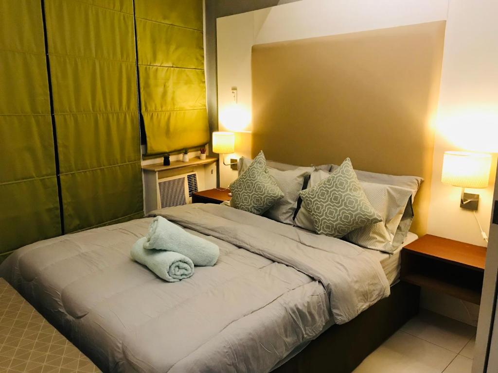 een slaapkamer met een groot bed met kussens bij Condo hotel MAKATI GREENBELT in Manilla