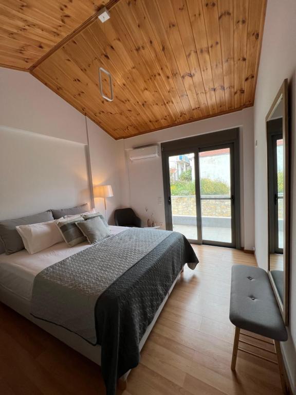 a bedroom with a large bed with a wooden ceiling at Koroni Luxury Maisonette in Koroni