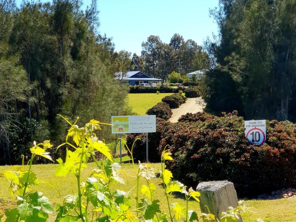 a garden with signs and flowers in a yard at Red Door Collective - RDC Vineyard Estate in Pokolbin