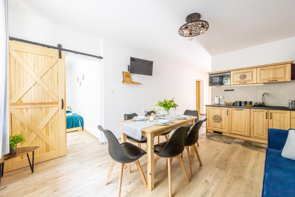 a kitchen and a dining room with a table and chairs at Czarna Góra Apartamenty TATRY GÓRY BIAŁKA T BUKOWINA T ZAKOPANE in Czarna Góra