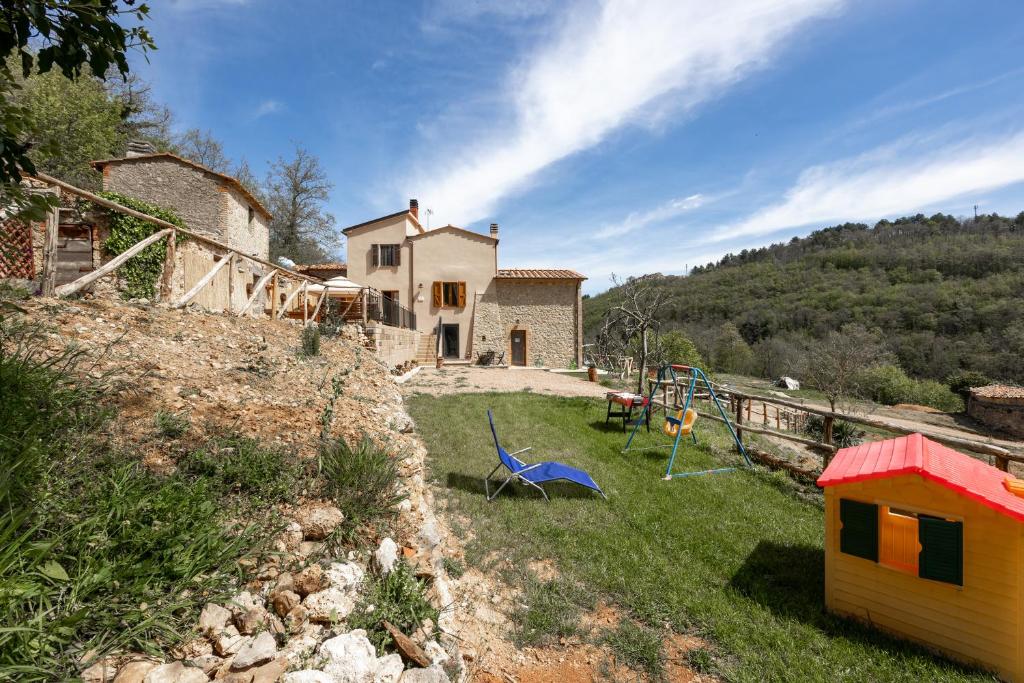 une maison au sommet d'une colline avec une cour dans l'établissement Podere del Ciacchi Among Tuscany Greenery - Happy Rentals, à Montieri