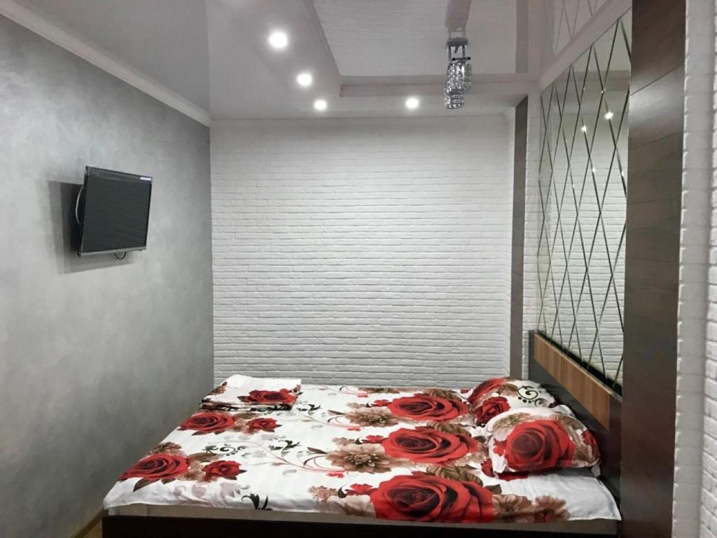 Un dormitorio con una cama con rosas rojas. en Новый Люкс в центре города по Алиханова, en Karagandá
