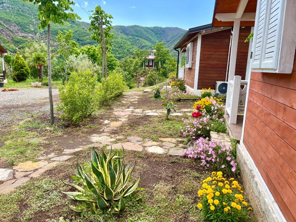 um jardim com flores ao lado de uma casa em Baven -Toven Naturae em Rubik